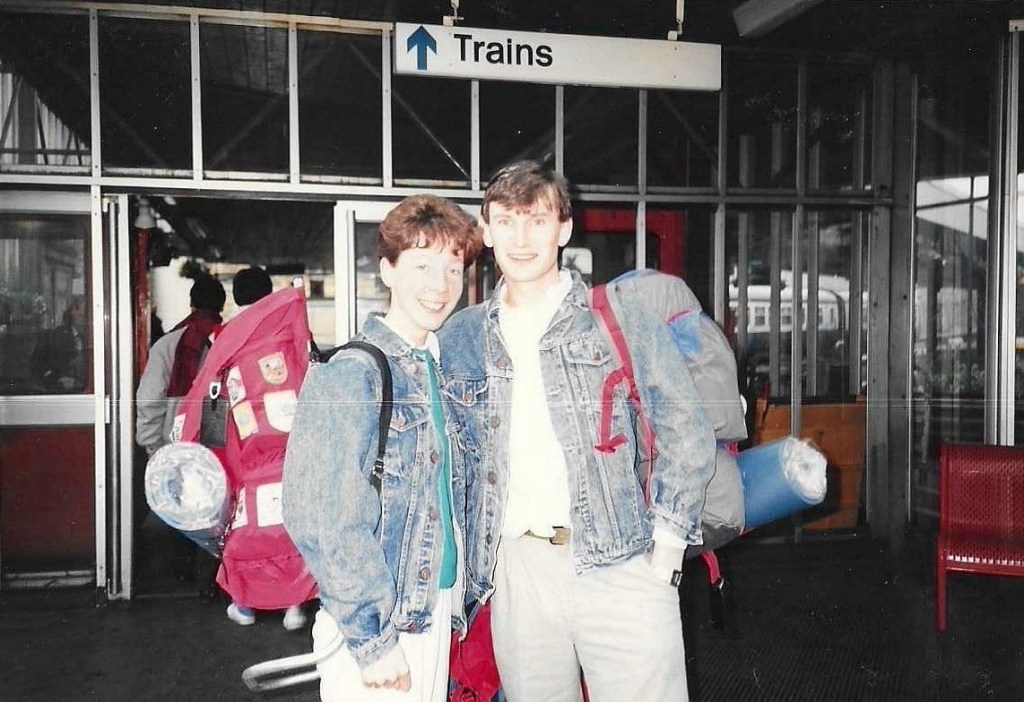 Olwen and Richard, both wearing denim jackets and carrying rucksacks, about to start their Interrail trip in 1988. Image credit: Olwen and Richard.